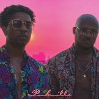 two men in sunglasses standing in front of a sunset